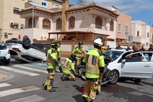 Equipo de bomberos y polícia trabajado sobre uno de los coches siniestrados.