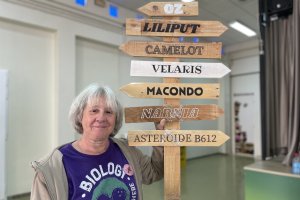 Pilar junto a señales de ciudades a las que solo se puede llegar leyendo.