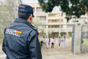 Un agente de la Policía Nacional en la puerta de un instituto.