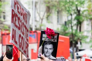 Una persona sujeta un cartel durante una concentración en la calle de Ferraz en apoyo al presidente del Gobierno.