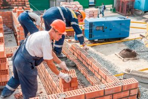 Trabajadores de la construcción poniendo ladrillos.