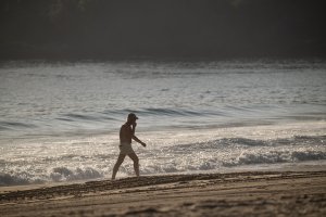 Foto de archivo de un hombre caminando por una playa.