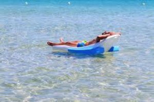 Persona tomando el sol en el mar. Imagen de archivo de Pixabay.