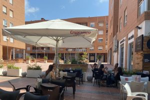 Un bar de Almería con sombrillas que publicitan cerveza.