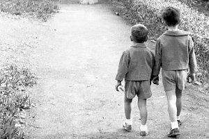 Dos niños con la merienda en la mano caminando por el Paseo de San Luis en los años 50.