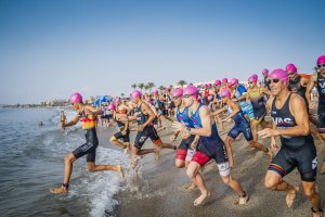 Los participantes del triatlón en su entrada al agua.