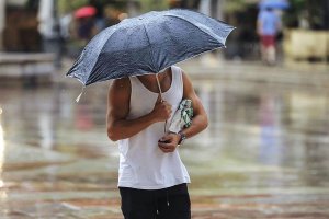 Imagen de archivo de un almeriense protegiéndose de la lluvia con un paraguas.