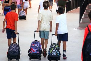 Imagen de archivo de niños llegando al colegio con sus mochilas.