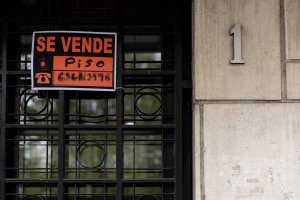 Vista de un cartel de ‘Se vende piso’ en un portal de un edificio.