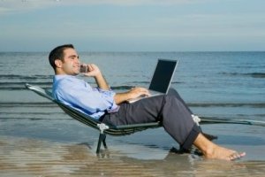 Una persona teletrabajando desde la playa.