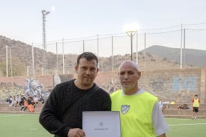 El presidente de la peña y el padre de la fallecida posando con una placa en honor a Leticia.