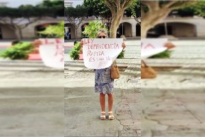 María del Rosario Romero, madre de Marina, mostrando un cartel reivindicativo.