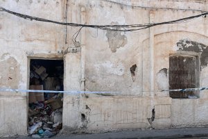 Imagen de la vivienda, sin puerta, precintada y llena de basura en su interior.