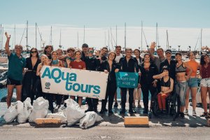 Participantes en la acción de limpieza de fondos marinos y algunos de los sacos con restos de la basura.