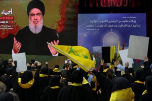 Partidarios del movimiento musulmán chiita libanés Hezbolá observan al líder del movimiento, Hassan Nasrallah, pronunciar un discurso