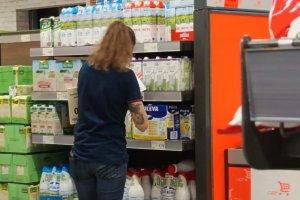 Una trabajadora de un supermercado cambia las etiquetas de los precios de los alimentos.