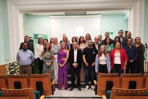 Foto de familia de los alumnos graduados junto a los miembros de la mesa inaugural.
