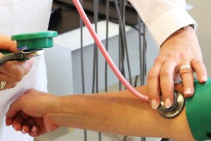 Un sanitario toma la tensión a un paciente.