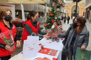 Voluntarios de Cruz Roja entregando el obsequio por la compra de pascueros.