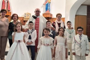 Primer grupo de primeras comuniones en la Iglesia de San Urbaño de
La Cañada: el párroco Fernando Peña acompaña a catequistas y jóvenes.