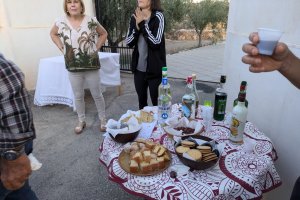 Una de las mesas con los dulces tradicionales y vecinas del lugar.