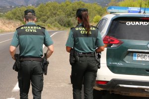 Dos agentes de la Guardia Civil montan guardia en una carretera.
