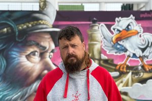 El artista Nauni69, junto al mural que le dio la victoria en la Liga Nacional de Grafiti.