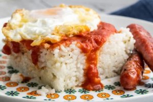 Un plato de arroz con huevo frito y salchichas. DEPOSITPHOTOS