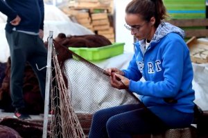 Silvia haciendo una de las cosas que más le relajan: remendar artes de pesca en el muelle de Roquetas.