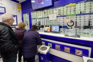 Varias personas compran décimos de Lotería en una administración de Loterías.