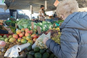 Una clienta observa uvas en el mercadillo de El Zapillo.