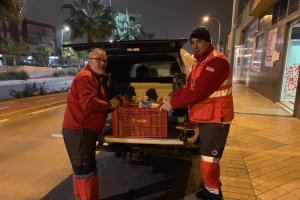 Voluntarios de la Cruz Roja llevan ropa de abrigo y comidas calientes a las personas en situación de calle.