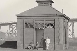 El mingitorio público que había junto al Cable Inglés, más o menos donde hoy está la Autoridad Portuaria; se ve a varios zagales que vivían de esperar a la tripulación de los barcos de carga en 1909.