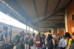 Viajeros esperan para subir al bus tras cancelarse el viaje en tren