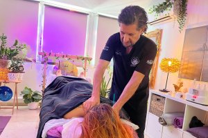 Manuel Romera atendiendo a una cliente en su consulta frente al mar.