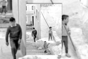 Un niño de la calle Valdivia con una pistola de juguete en la mano, junto a otro que coge el palo de madera de sujetar la ropa tendida como si fuera una lanza.