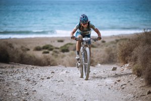Una corredora asciende con el Mediterráneo de fondo durante una de las pruebas de la Škoda Titan Desert Almería.