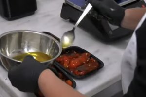 Pimientos 'El Leñero' asados a la leña y siendo rociados con aceite