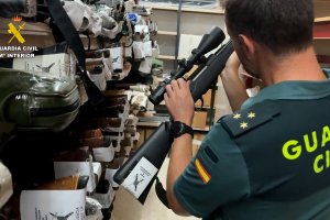 Capitán de la Guardia Civil inspeccionando un arma de fuego.