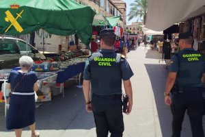 Dos agentes de la Guardia Civil patrullan en un mercadillo de Almería.