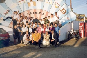 En su décimo Aniversario socios y camareros junto a la portada de la caseta.