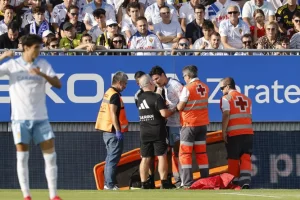 El jugador de pie pidiendo volver al campo pero no se lo permitieron.