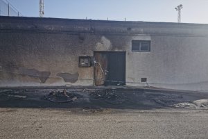 Imagen de los restos de los contenedores quemados, junto al colegio de la pedanía.