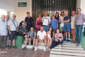 Manolo Hidalgo con una placa, en la puerta del edificio de Aguadulce con los vecinos.