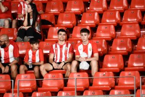 Jóvenes aficionados en el Almería-Sporting rodeados de butacas vacías.