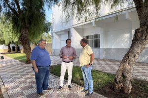 Representantes del PSOE de Roquetas de Mar junto a uno de los edificios de los alumnos de Las Marinas