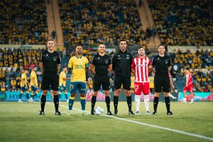 La foto de los capitanes y el equipo arbitral.