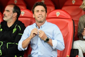 El entrenador catalán del Almería se ajusta el botón de la camisa en el banquillo del Estadio de los Juegos Mediterráneos.