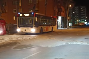 Un autobús del transporte público urbano de la capital pasando a baja velocidad sobre la acumulación de arena.