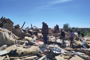 Un habitante del asentamiento chabolista busca entre los escombros sus enseres personales.
